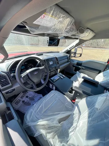 Exterior view of small fire truck showing cab, body compartments, and wheel/tire area.
