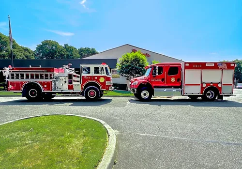 Exterior view of small fire truck showing cab, body compartments, and wheel/tire area.