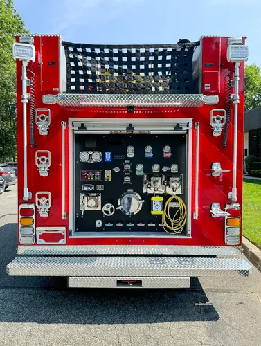 Exterior view of small fire truck showing cab, body compartments, and wheel/tire area.