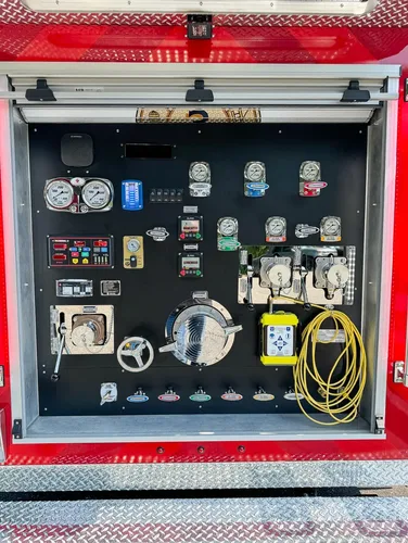 Exterior view of small fire truck showing cab, body compartments, and wheel/tire area.