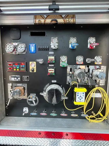 Exterior view of small fire truck showing cab, body compartments, and wheel/tire area.