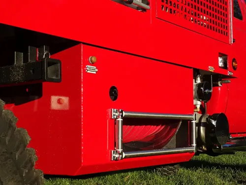Exterior view of small fire truck showing cab, body compartments, and wheel/tire area.