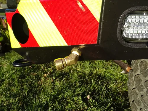 Exterior view of small fire truck showing cab, body compartments, and wheel/tire area.