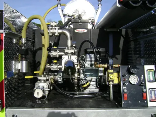 Exterior view of small fire truck showing cab, body compartments, and wheel/tire area.
