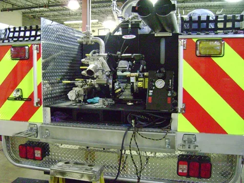 Exterior view of small fire truck showing cab, body compartments, and wheel/tire area.