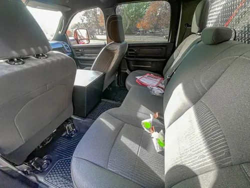Exterior view of small fire truck showing cab, body compartments, and wheel/tire area.