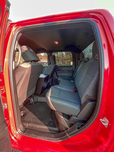 Exterior view of small fire truck showing cab, body compartments, and wheel/tire area.