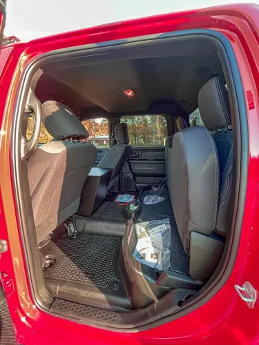 Exterior view of small fire truck showing cab, body compartments, and wheel/tire area.