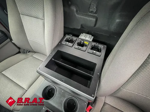 Exterior view of small fire truck showing cab, body compartments, and wheel/tire area.