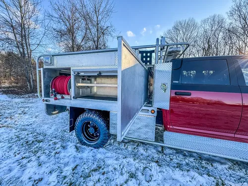 Side view with multiple utility-body compartment doors opened.