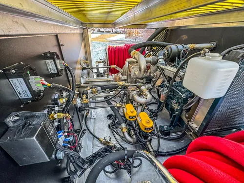 Open engine bay view showing engine components and hoses.