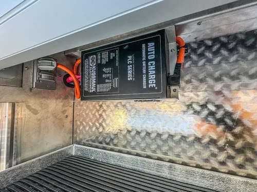 Compartment interior with battery charger and electrical connections.