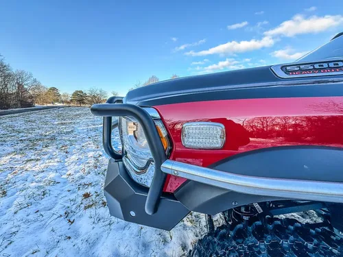 Front-left fender and brush-guard close-up near the headlight.