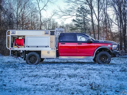 Full left-side profile of the truck and utility body in a snowy lot.