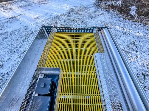 Top walkway close-up with yellow grating and mounted hardware.