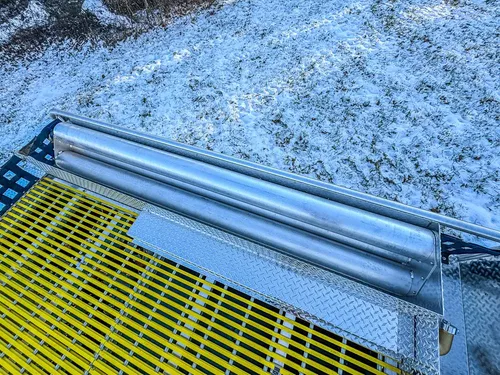 Close-up of upper side rail above the yellow grated deck.