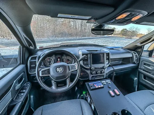 Wide front-cab interior view showing steering wheel, dashboard, and center console.