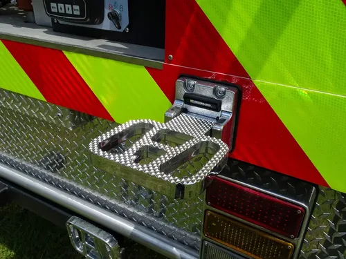Exterior view of small fire truck showing cab, body compartments, and wheel/tire area.