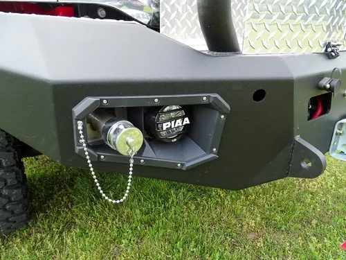Exterior view of small fire truck showing cab, body compartments, and wheel/tire area.