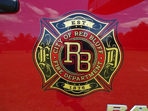 Exterior view of small fire truck showing cab, body compartments, and wheel/tire area.