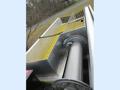 Exterior view of small fire truck showing cab, body compartments, and wheel/tire area.