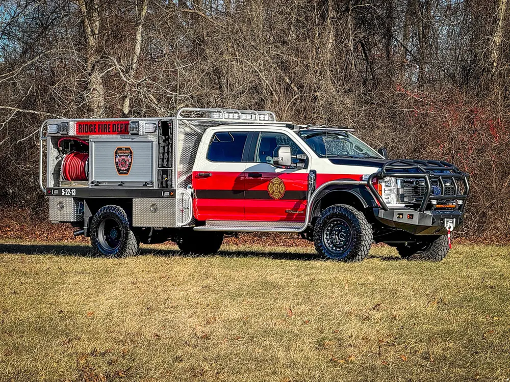 Front-left three-quarter exterior view of the red-and-white brush truck.