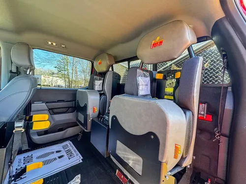 Rear passenger compartment view showing bench seat and mesh divider.
