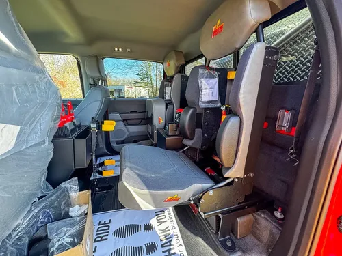 Wide rear cabin view showing bench seat, front seatbacks, and divider.