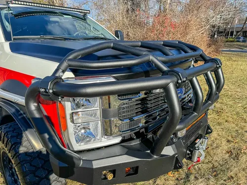 Front-left close-up of headlight area and heavy brush guard tubing.