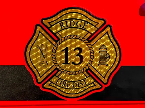 Close-up of fire department crest and number decal on the red cab door.