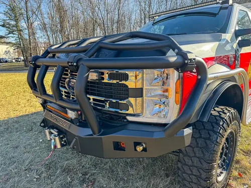Front-left corner close-up of grille, brush guard, and bumper.