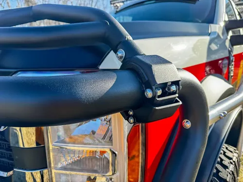 Brush guard side close-up with mounted warning light and hardware.