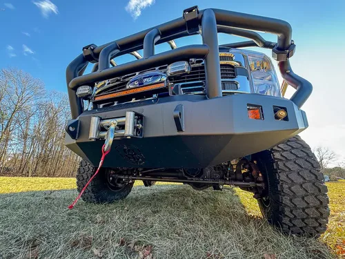 Low front-left angle showing bumper, brush guard, and winch line.