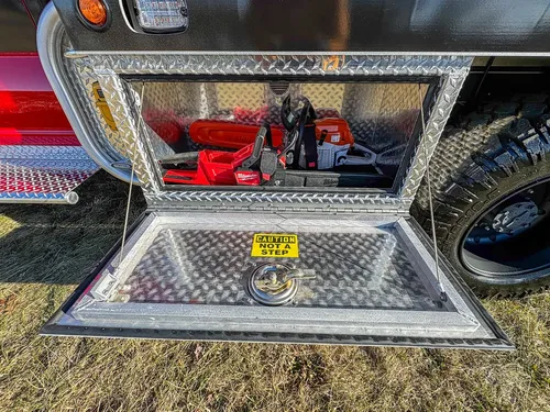 Open lower side compartment with mounted rescue tools on a tray.