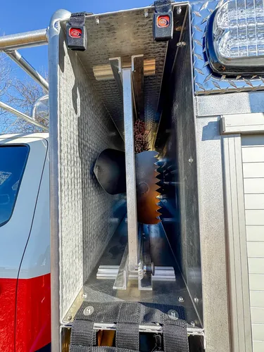 Compartment interior close-up with metal cutting blade and dark storage bin.