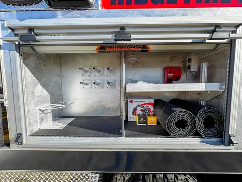 Open upper side storage compartment with shelves and loose equipment.