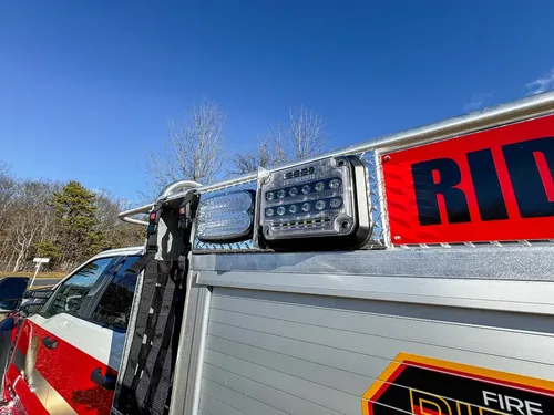 Upper side body close-up with warning lights and reflective red stripe.
