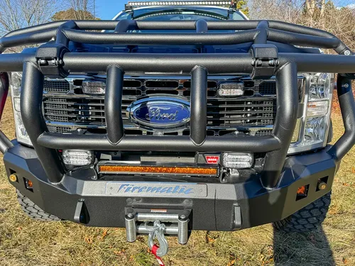 Front bumper close-up with brush guard, warning lights, and winch mount.