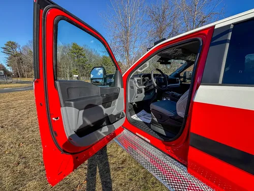 Driver door open exterior view showing the front cab entry area.