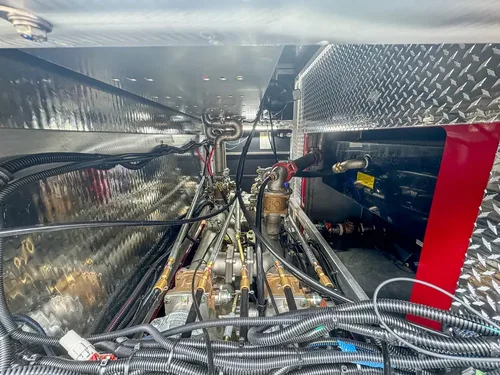 Deep side equipment bay with hoses and tools inside.
