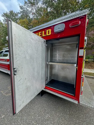 Open side compartment with shelf and smooth metal interior.