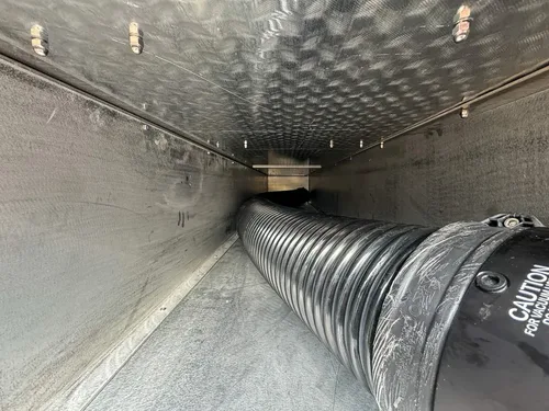 Inside long top-side tube compartment with coiled hose stored.