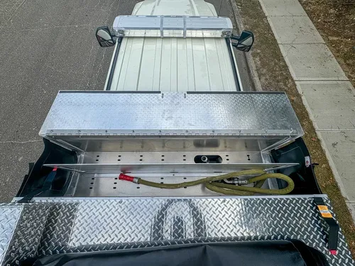 Top rear deck view toward cab with open panel and hoses visible.
