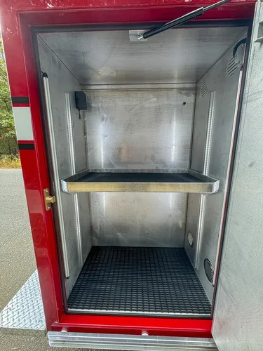 Open side compartment with shelf and empty interior bay.