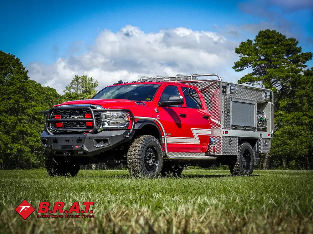 Exterior view of small fire truck showing cab, body compartments, and wheel/tire area.