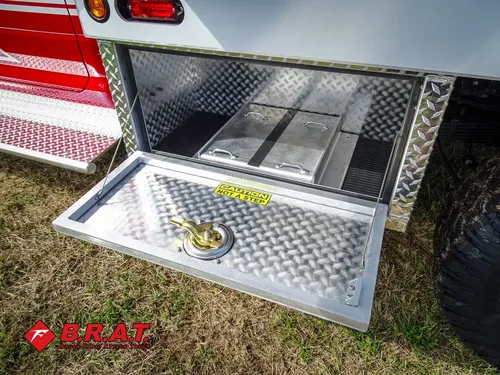 Exterior view of small fire truck showing cab, body compartments, and wheel/tire area.