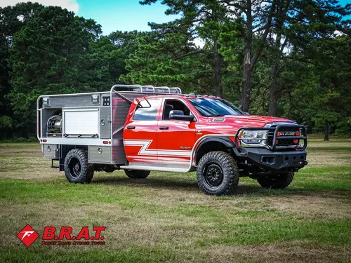 Exterior view of small fire truck showing cab, body compartments, and wheel/tire area.