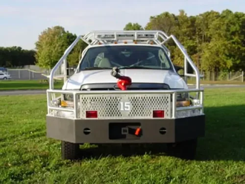 Exterior view of small fire truck showing cab, body compartments, and wheel/tire area.
