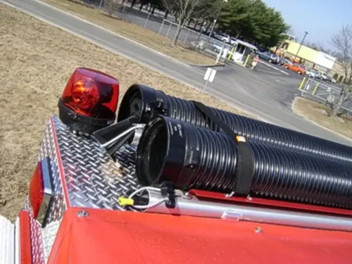 Exterior view of small fire truck showing cab, body compartments, and wheel/tire area.