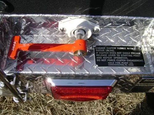 Exterior view of small fire truck showing cab, body compartments, and wheel/tire area.